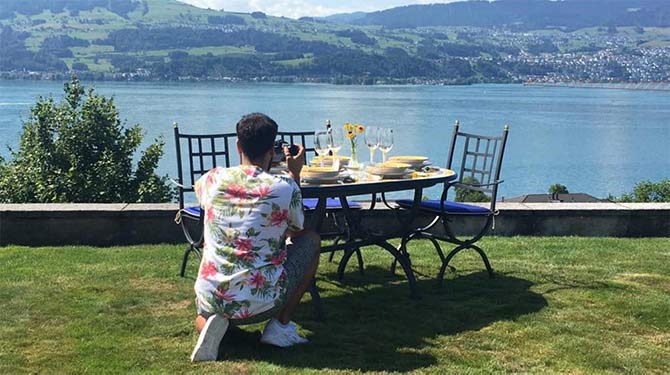 Man in shirt photographs Italian table on terrace